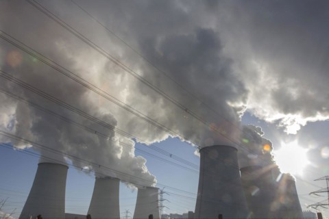 Steam rises from the cooling towers of the Vattenfall power plant in Jaenschwalde, power lines and
