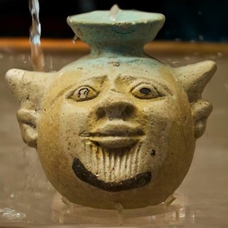 Aryballos, in the shape of the head of Acheloos, a river god, in antique ceramic vessel with funny