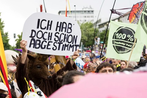 Dancer of the group 100% Tempelhofer Feld dressed as a Berlin bear with a sign Ich hab doch schon