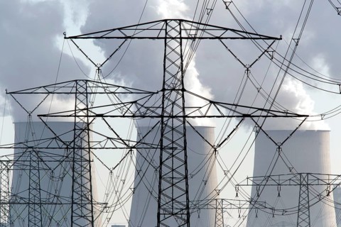Steam rises from the cooling towers of the Vattenfall power plant in Jaenschwalde, power lines and