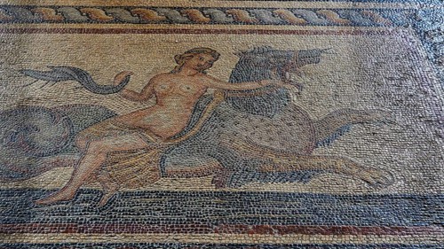 Antique mosaic of a mythological figure on a mythical creature, a nereid riding a hippocampus,