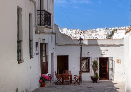 Tables and chairs of a small street cafe in the white town of Vejer in the mountains, Andalusia,