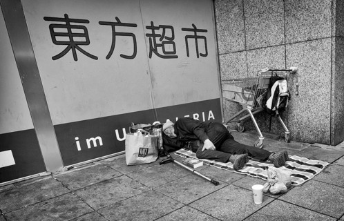Homeless, Berber, sleeping, lying on pavement, Bible, shopping trolley, belongings, bag, Chinese