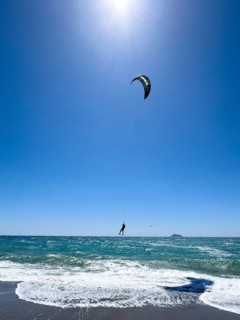 Kitesurfer Kitesurfer takes off in strong wind and waves rough sea moving sea flies with inflated