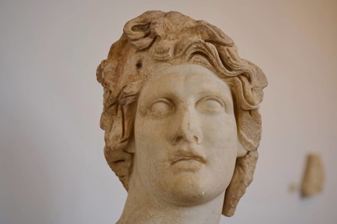 Helios, sun god, close-up of a damaged marble head with wavy hair, ancient aesthetics, interiors,