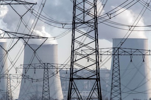 Steam rises from the cooling towers of the Vattenfall power plant in Jaenschwalde, power lines and