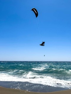 Kitesurfer Kitesurfer takes off in strong wind and waves rough sea moving sea flies with inflated