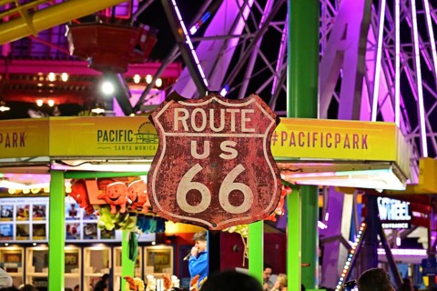Route 66 sign in front of the Ferris wheel on the pier in Santa Monica, Californi