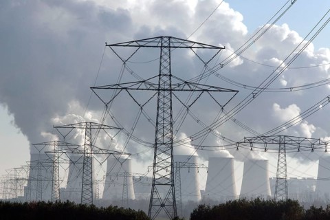 Steam rises from the cooling towers of the Vattenfall power plant in Jaenschwalde, power lines and