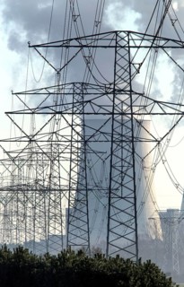 Steam rises from the cooling towers of the Vattenfall power plant in Jaenschwalde, power lines and