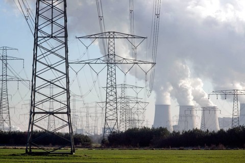 Steam rises from the cooling towers of the Vattenfall power plant in Jaenschwalde, power lines and