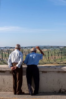 Senior citizen looking over a parapet on the street, Vejer, Andalusia, Spain, Europe