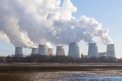 Steam rises from the cooling towers of the Vattenfall power plant in Jaenschwalde, power lines and