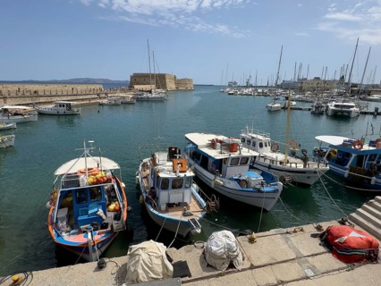 Several small fishing boats in historic Venetian harbour of Heraklion, left in the background
