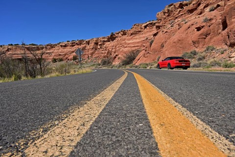 Red Ford Mustang convertible on the roadside of historic Route 66, Dead Man's Curve, New Mexico