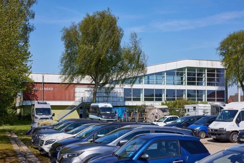 Car park and indoor swimming pool in Niebuell, Nordfriesland district, Schleswig-Holstein, Germany,