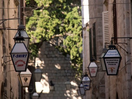Old town street with hanging lanterns and shop signs, the old town of Dubrovnik with historic