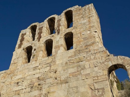 Ancient stone structure with several arches in front of blue sky, Ancient building with columns and