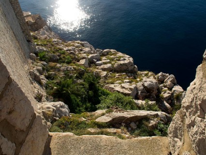 Rocky coast sloping into the sunny sea, the old town of Dubrovnik with historic houses, churches,