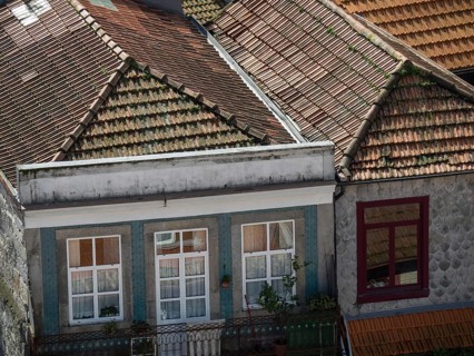 Old buildings with classic red tiled roofs and small balconies that convey a traditional urban