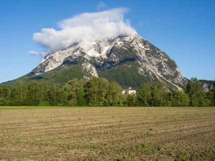 Farmland, behind the Grimming and Trautenfels Castle in the morning light, near Irdning, Styria,