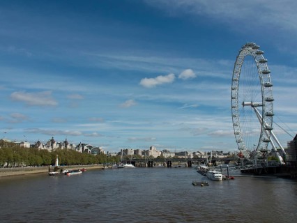 View of the River Thames in London with the London Eye and city views in the background under a