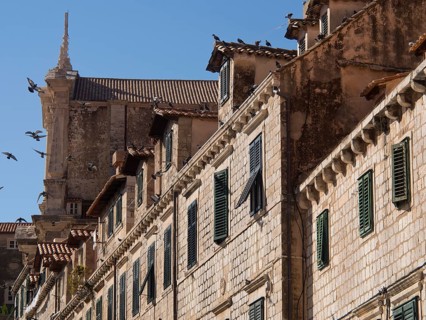 Stone buildings with battlements and wooden shutters in a historic old town, the old town of