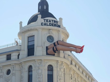Theatre building with a striking sculpture of legs protruding from the facade, Madrid, Spain,