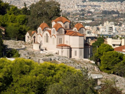 Small church with several domes surrounded by trees and cityscape on a hill, Ancient buildings with