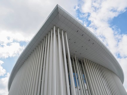 Close-up of a modern building in Luxembourg with vertical columns and blue sky in the background,