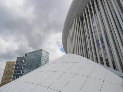 White dome and modern glass buildings in Luxembourg under a cloudy sky, modern buildings with trees