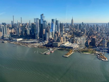 City view by day with skyscrapers and river in the foreground under a clear sky, the skyline of new