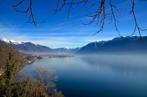 Panoramic View over Lake Maggiore with Snowcapped Mountain in a Misty Morning and in a Sunny Day in
