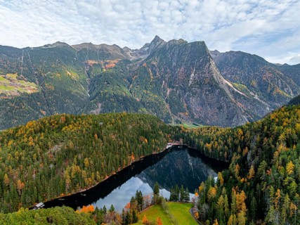 Aerial view, mountain peaks of the Oetztal Alps reflected in Lake Piburger See, in autumn, near