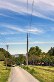 Foehn sky and narrow road with wooden electricity pylons, Allgaeu, Bavaria, Germany, Europe