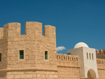 Close-up of a historic fortress with stone walls against a clear blue sky, Tunis in Africa with
