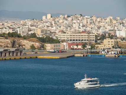 A boat sails in the harbour, in the background numerous buildings of the city, Ancient buildings