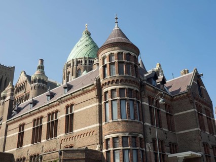 Historic Gothic church with imposing towers and multiple windows under a clear blue sky, Haarlem,