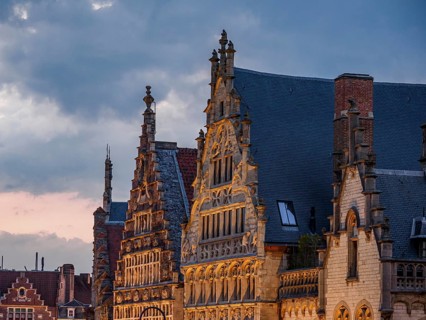 Ornate historic buildings with gabled roofs in Bruges in the light of dusk, historic buildings with
