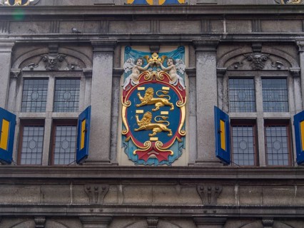 Coat of arms decorated building facade with windows and ornate architectural details, historic