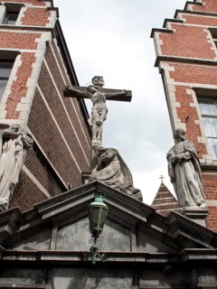 Statue of a crucifixion scene on a historical building under a cloudy sky, Historical Buildings,