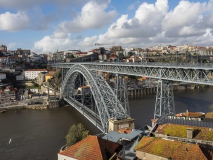 Steel bridge over a river in a historic city in sunny weather with clouds, spring in the old town