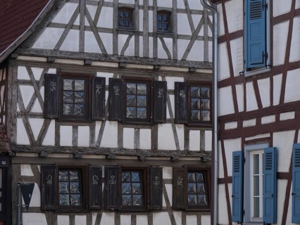 Close-up of a half-timbered house with dark shutters and stylistic accents, historic half-timbered