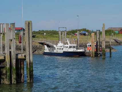 Boats in the harbour, surrounded by jetties and buildings in sunny weather, Baltrum Germany