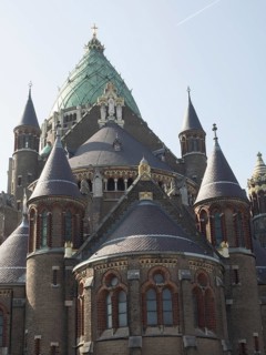A magnificent Gothic cathedral with a green dome, rich in architectural details and towers,
