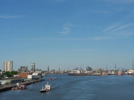 Panoramic view of an urban harbour landscape with boats and cranes under a blue sky, a picturesque