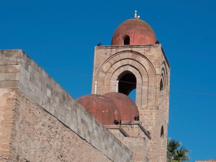 Historic church with red domes and towers against a clear blue sky, palermo in sicily with an