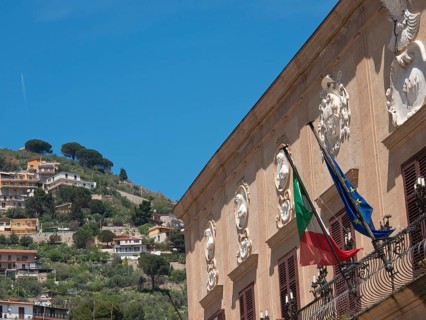 Italian and European flag building decorated and set in a hilly landscape on a sunny day, palermo