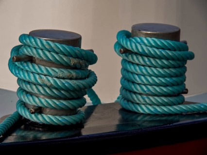 Close-up of two blue-wrapped mooring lines on a boat, historic houses in Hoorn and ships in the