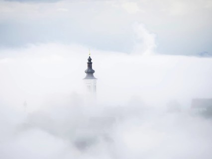 Church tower rises out of the morning mist, Frauenberg pilgrimage church, near Leibnitz, Styria,